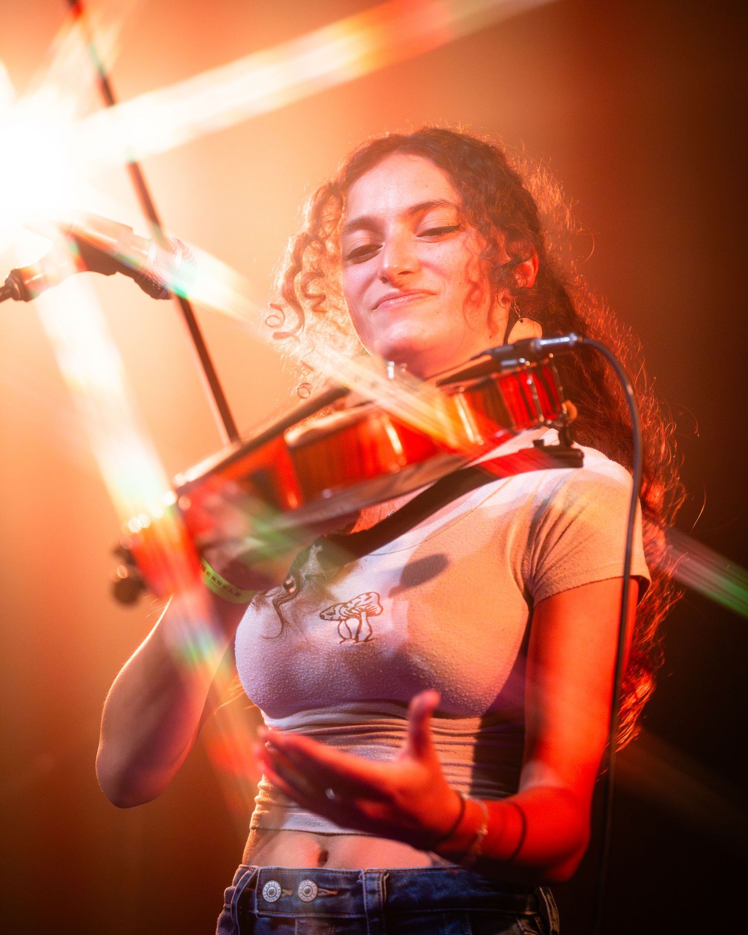 Live performance captured in warm orange lighting showing energetic stage presence.