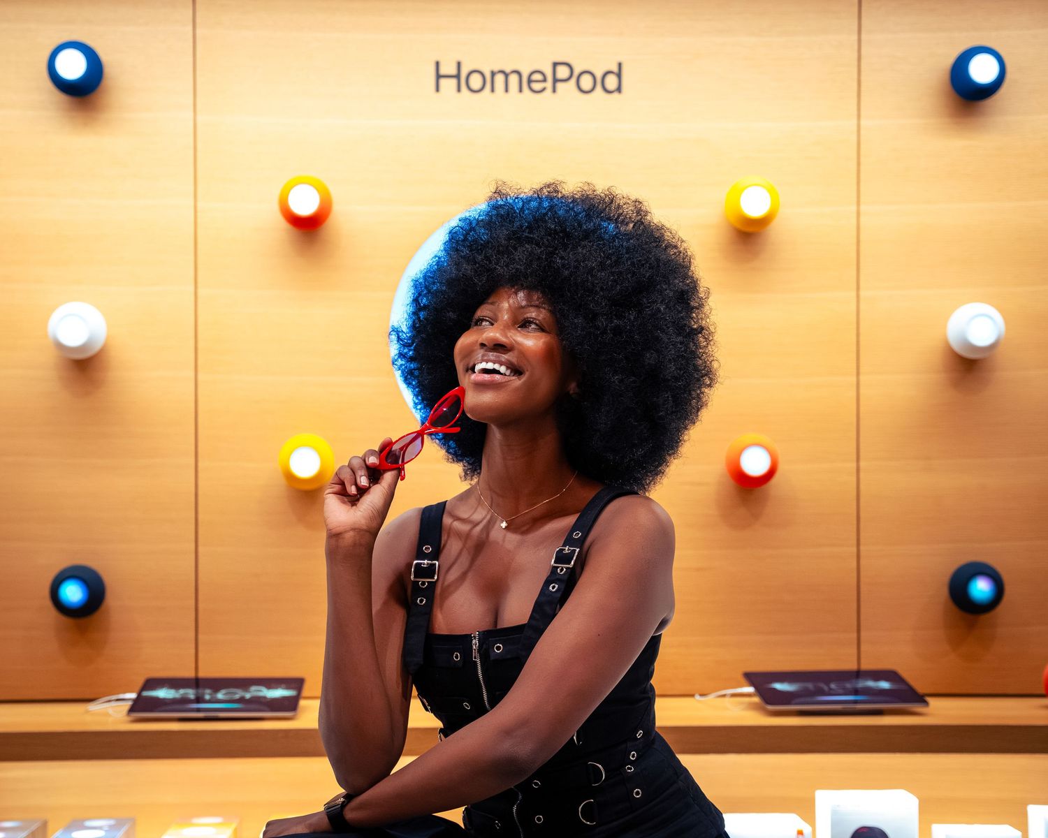 Performer sings in front of HomePod display with warm lighting and colorful background.