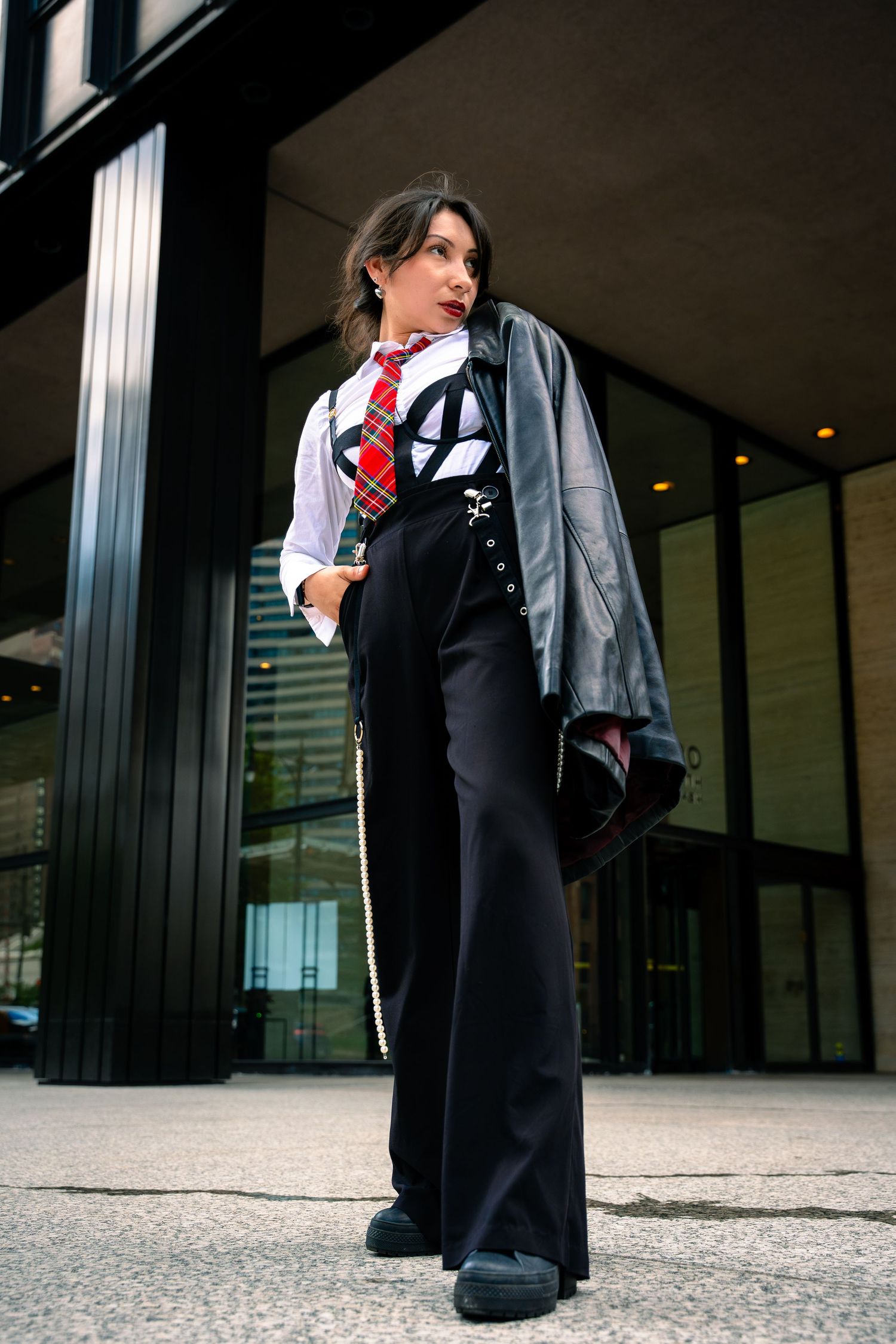 Dramatic low-angle fashion shots featuring formal attire and red tie against modern architecture.