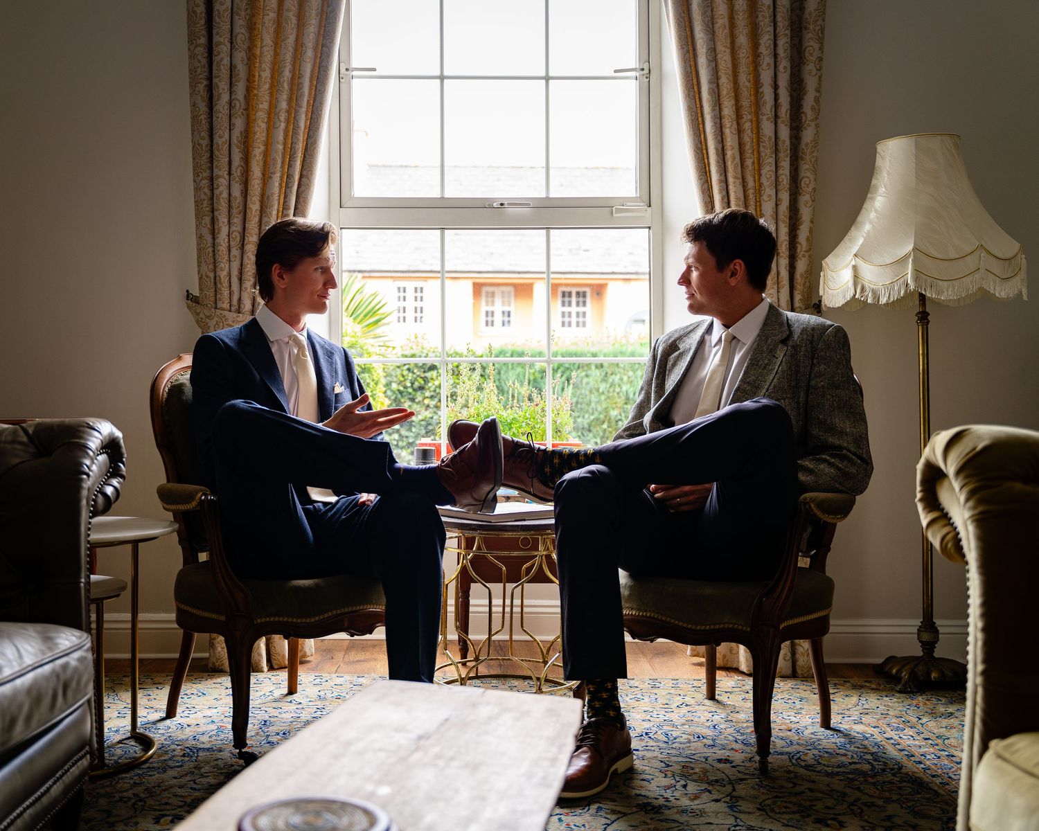 Two armchairs arranged for conversation in elegant room with natural window light.