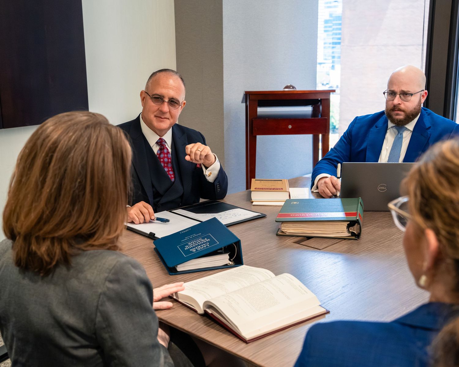 Business meeting in progress with professionals gathered around conference table.