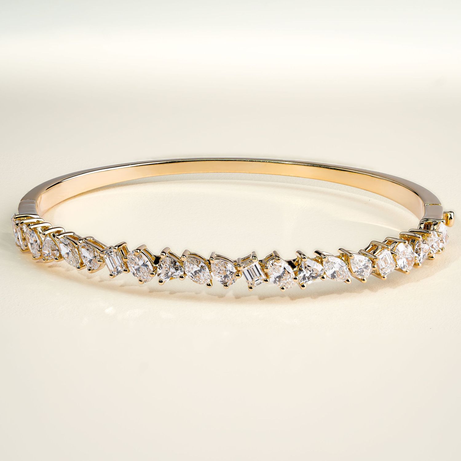 Rose gold bangle bracelet with graduated crystal accents along the curve.