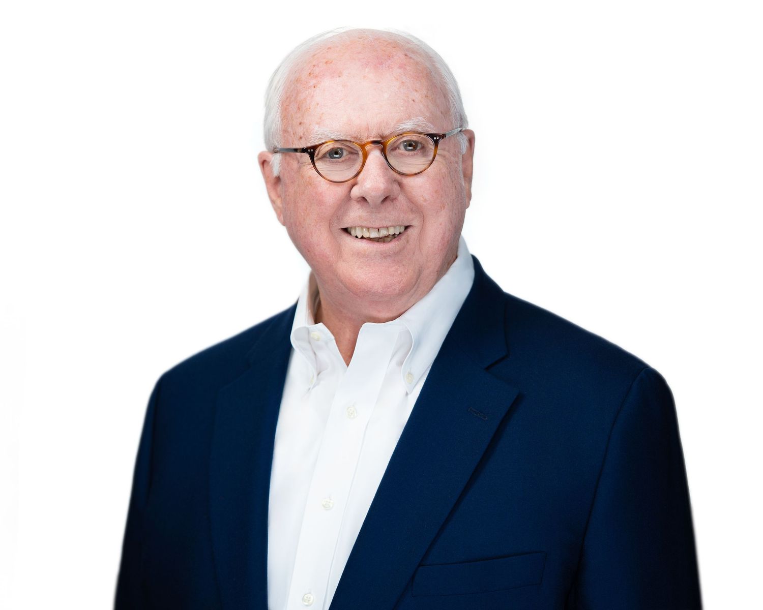 Business professional portraits in navy blazer and white shirt against clean background.