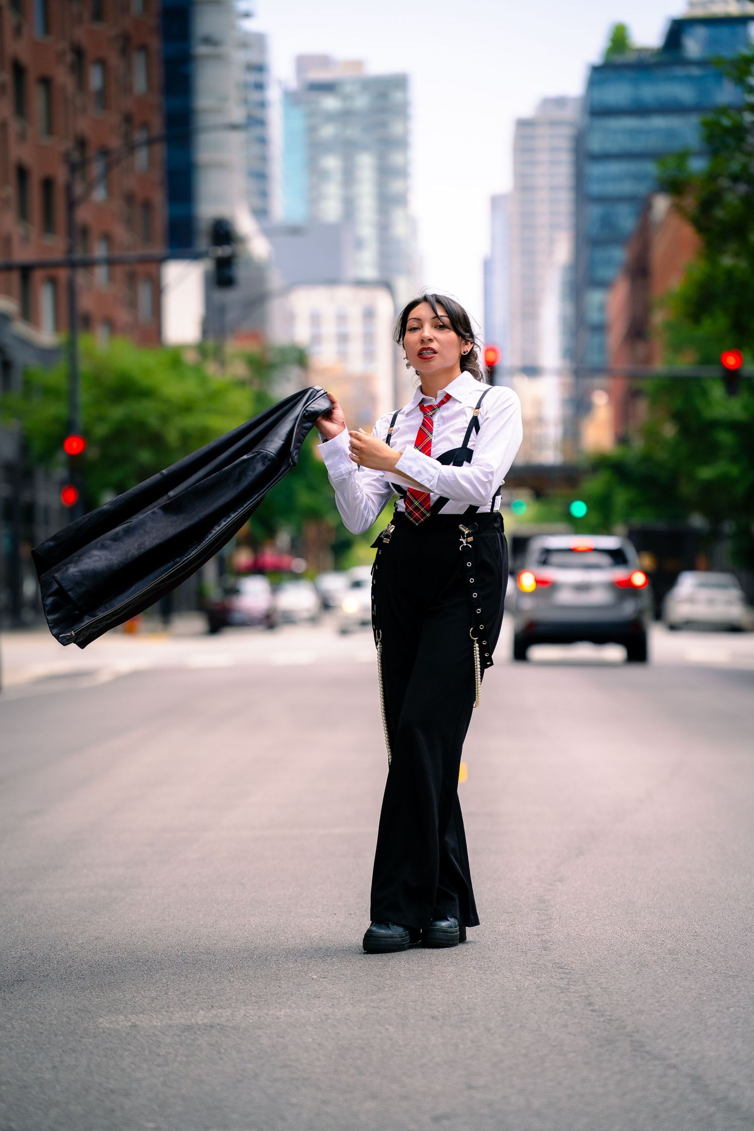 Dynamic street style photo featuring black pants and white shirt ensemble in urban setting.
