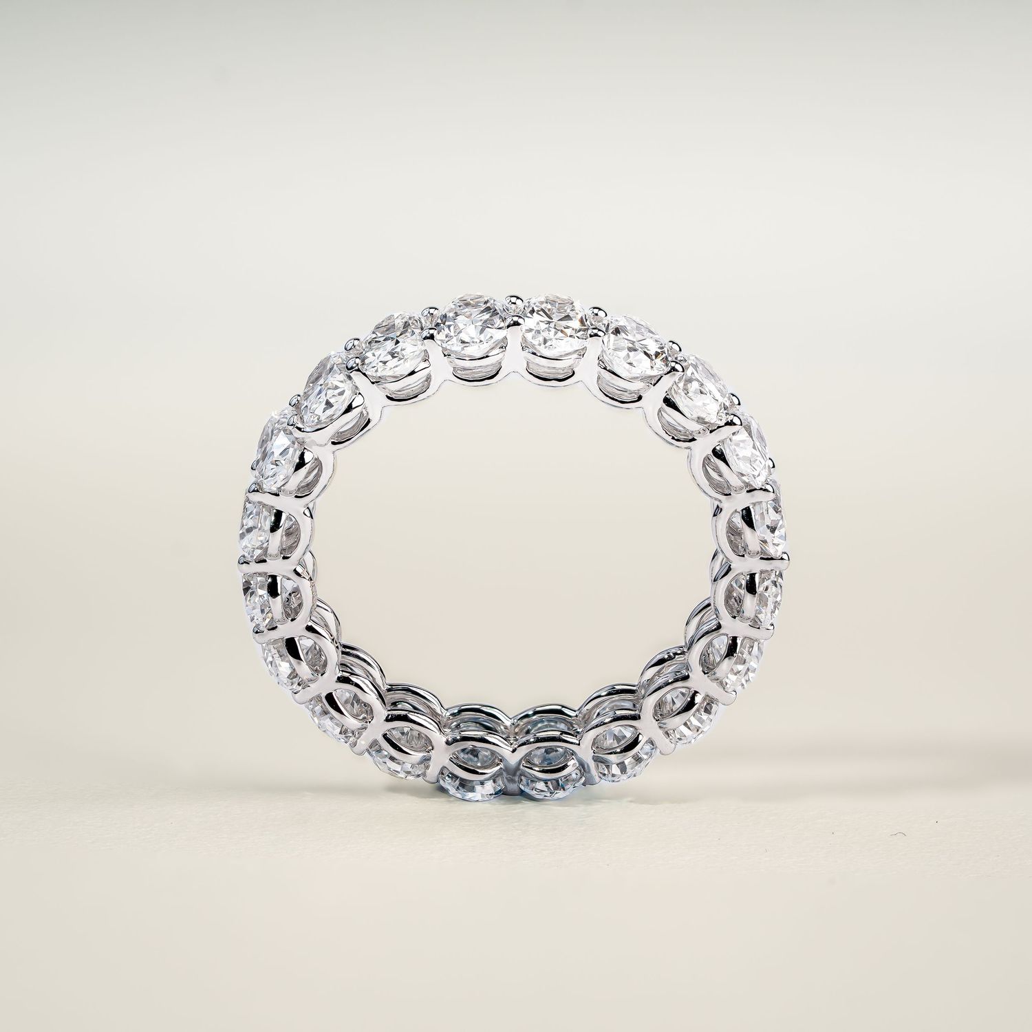 Delicate white gold eternity band with round diamonds shown from multiple angles.