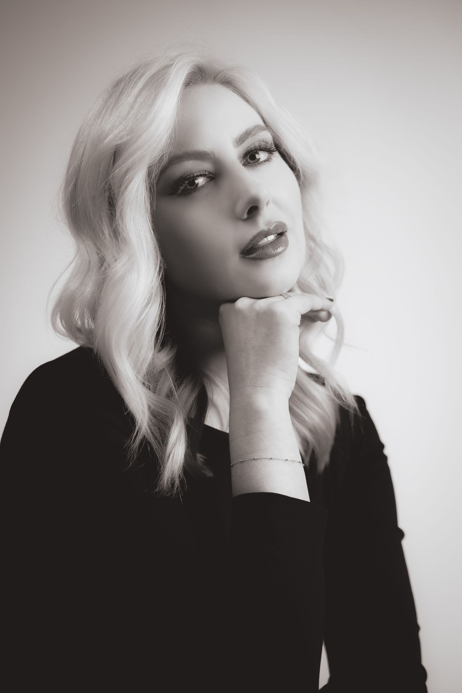 A series of black and white fashion portraits showing dramatic poses against a light background.