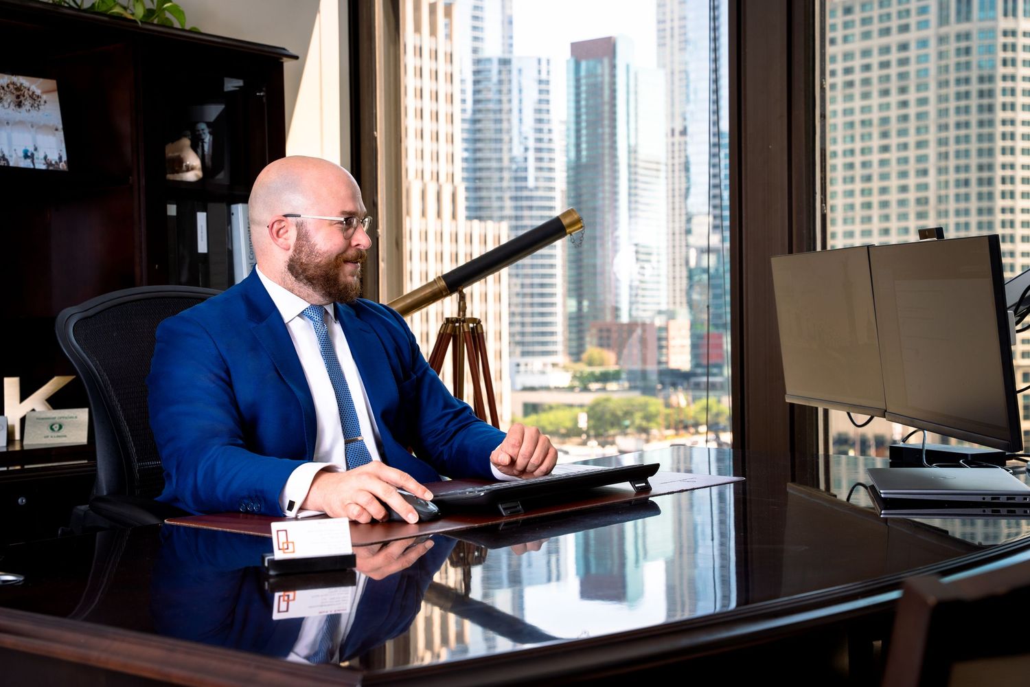 Professional workspace with modern office desk overlooking urban high-rise buildings.