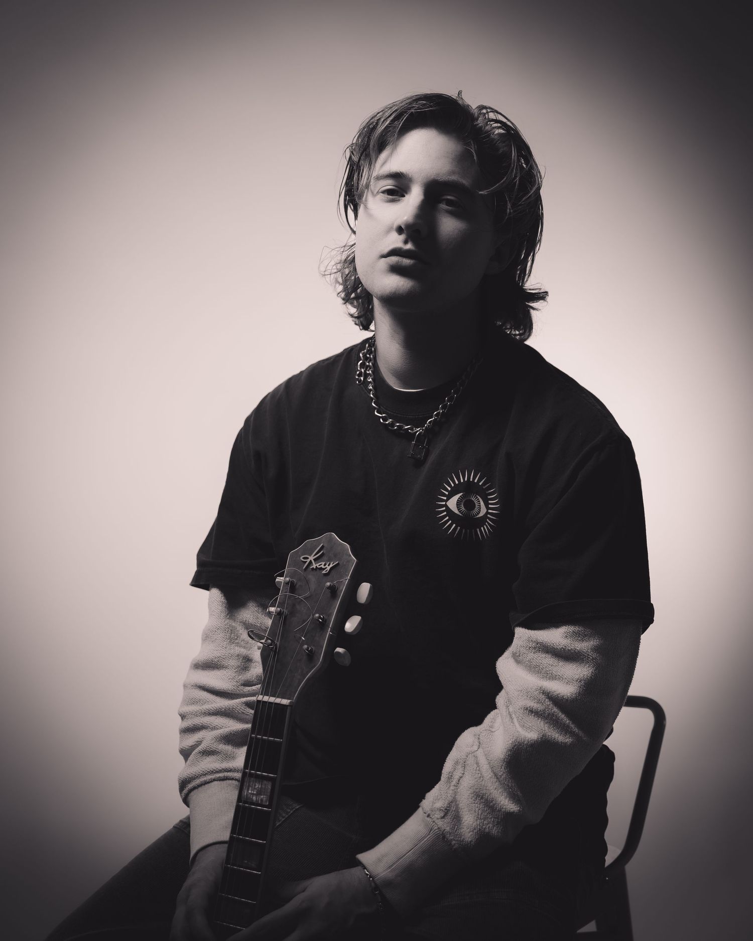 Artistic black and white portraits of musician with guitar in contemplative poses.