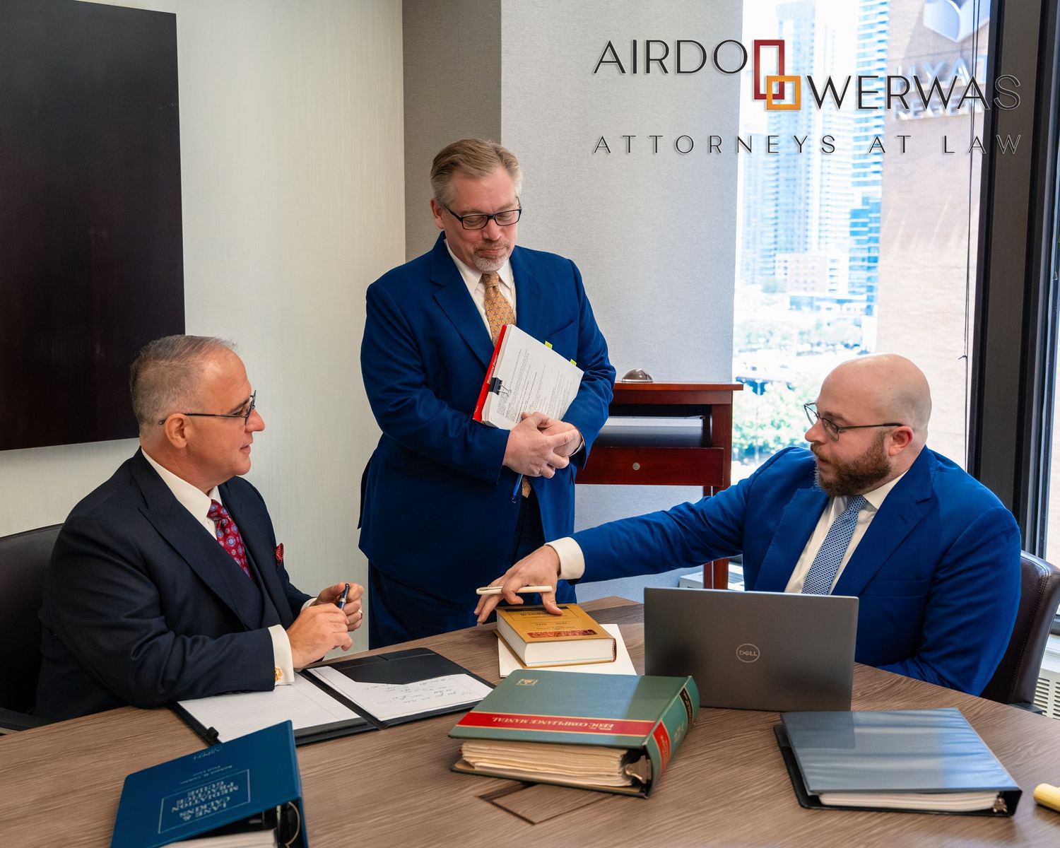 Law firm team engaged in strategic discussion at conference table.