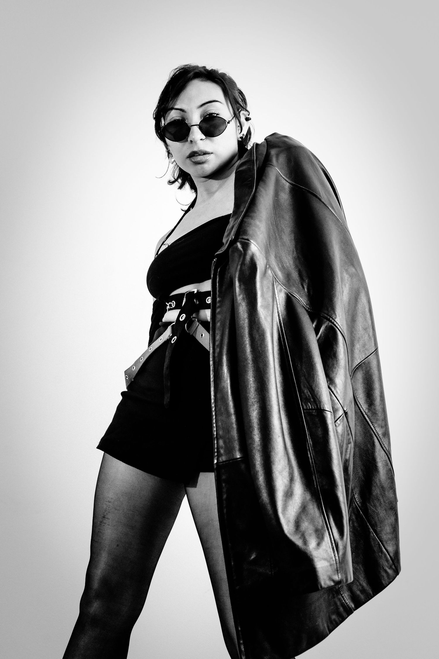 Edgy fashion portraits in black and white featuring leather jacket and sunglasses.