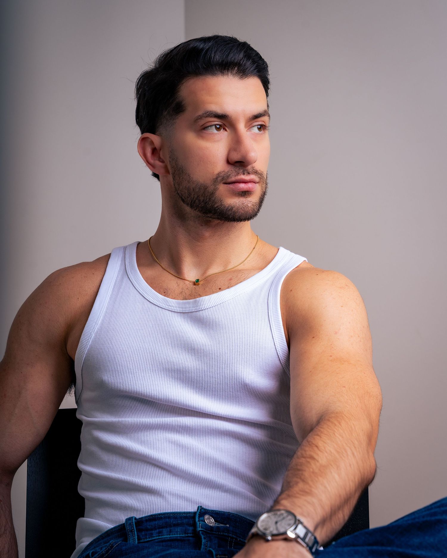 Studio portrait series featuring classic white tank top and denim styling.