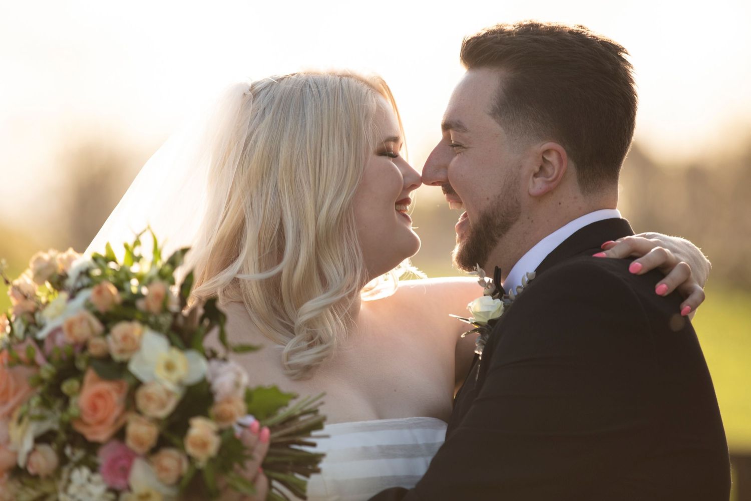 Romantic sunset wedding portraits with couple embracing among floral arrangements.
