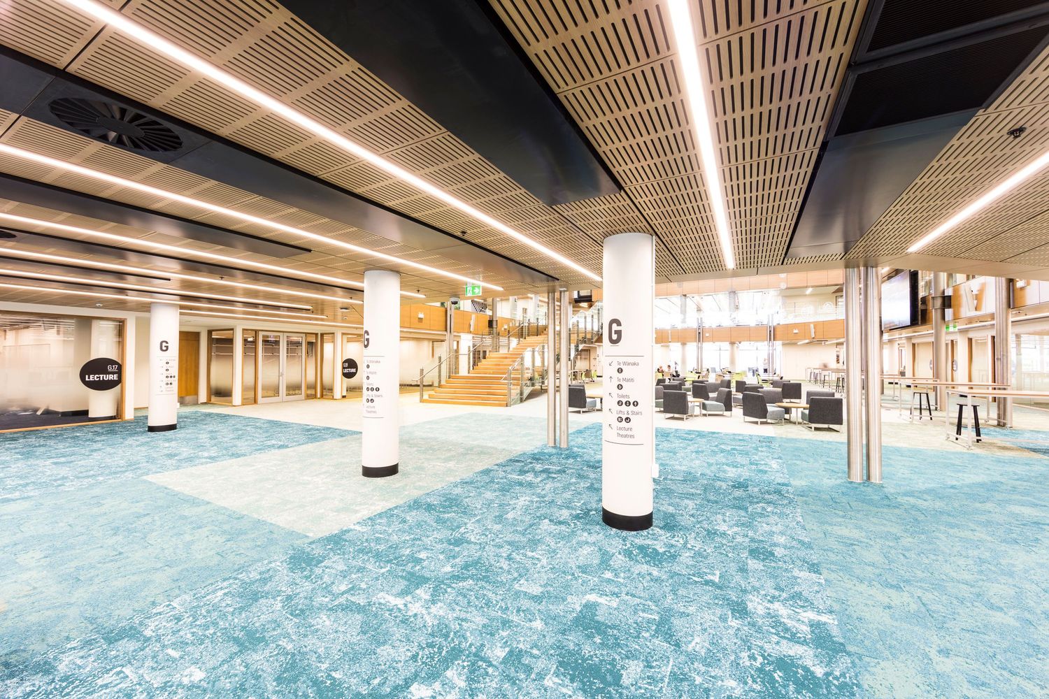 Indoor swimming pool with sleek architectural design featuring wood beam ceiling and ambient lighting.