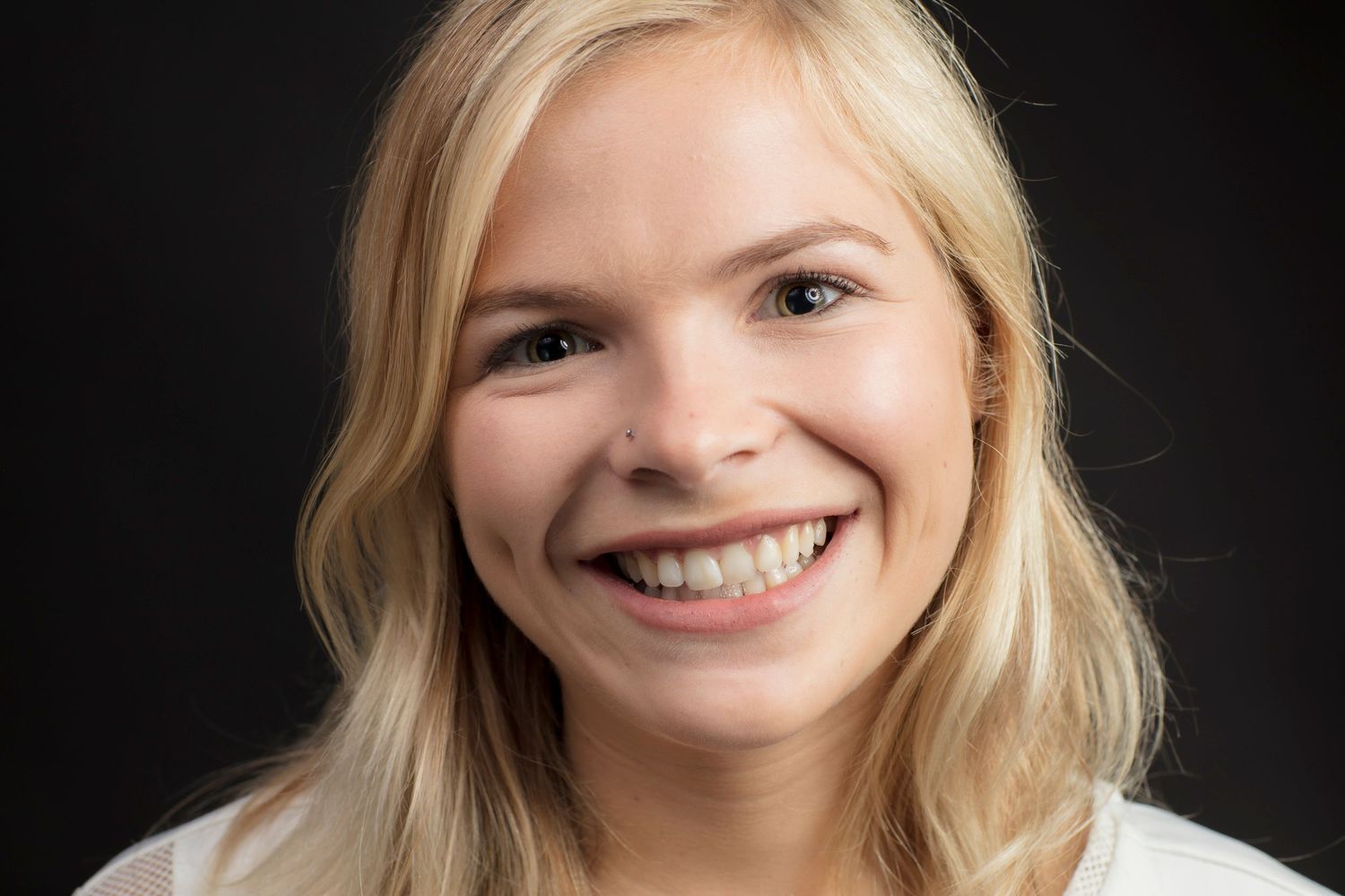 Professional headshots featuring bright expressions against dark background.