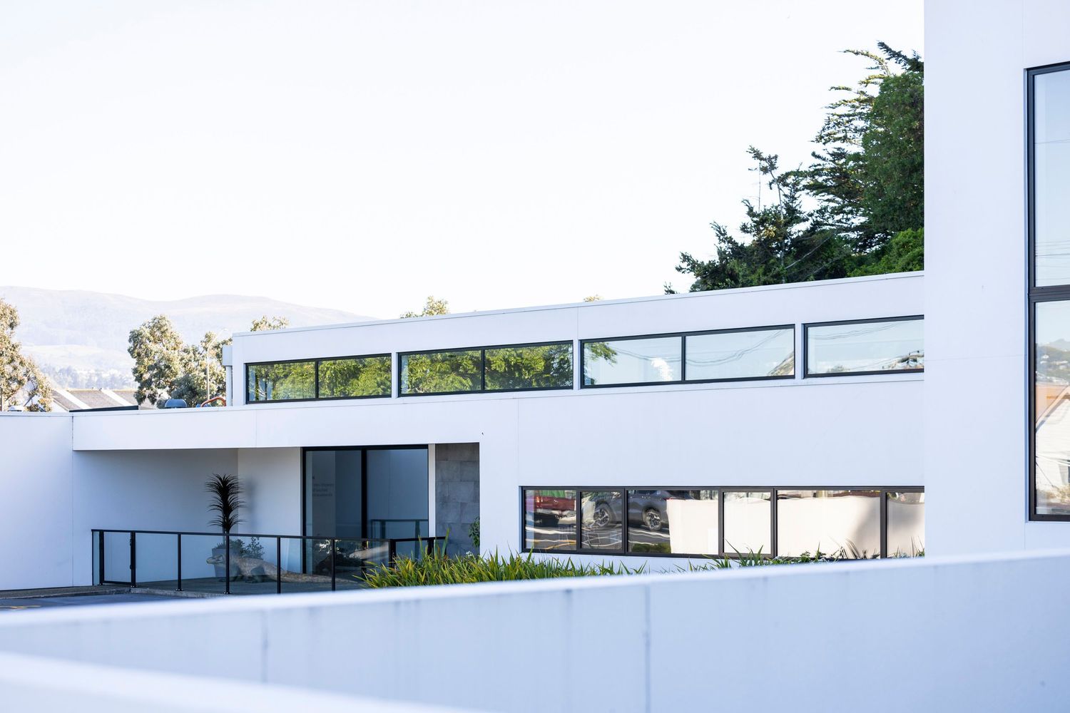 Contemporary white building with horizontal windows and clean architectural lines.