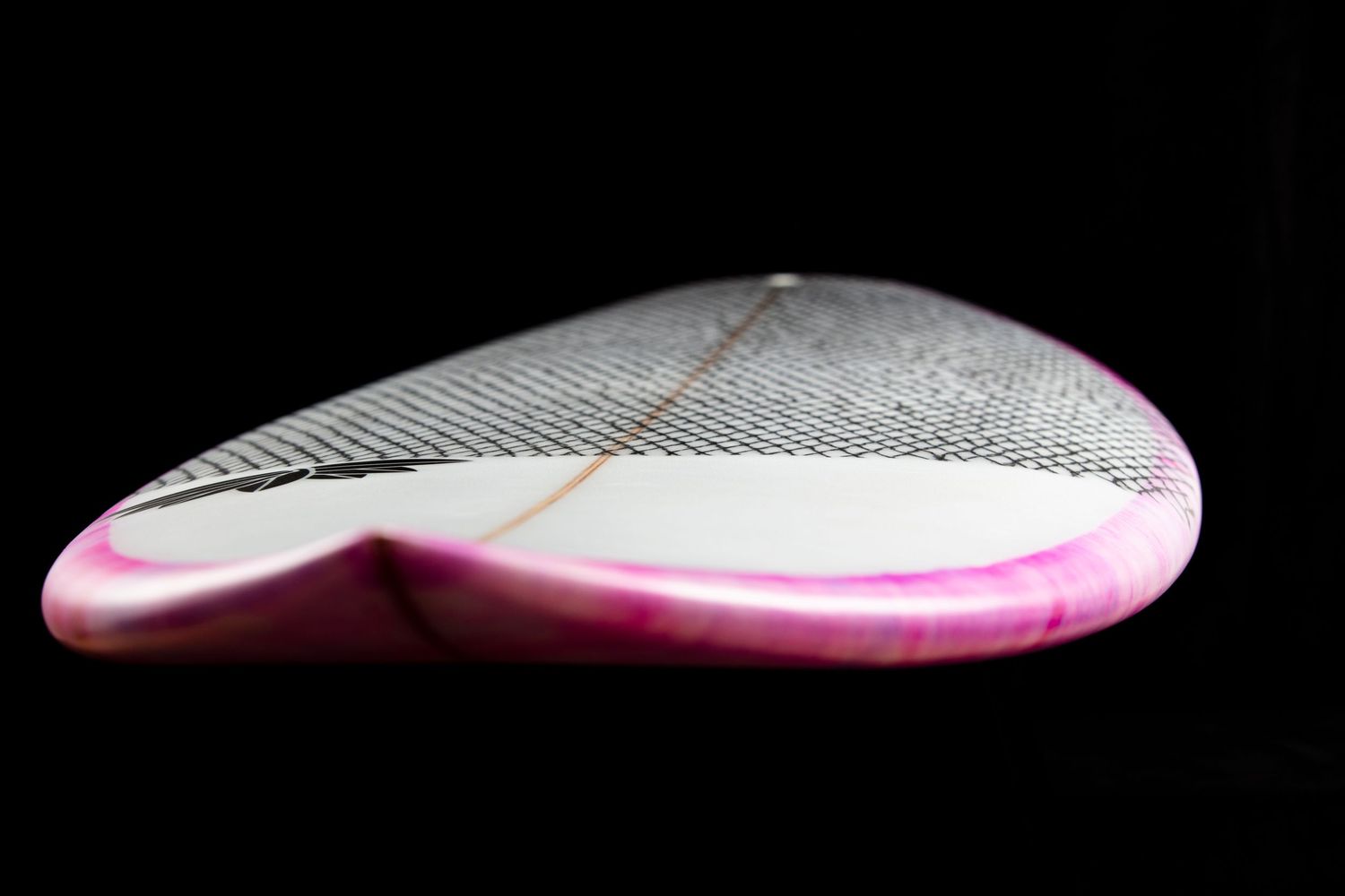Close-up of a pink and white surfboard grip pad texture against black background.