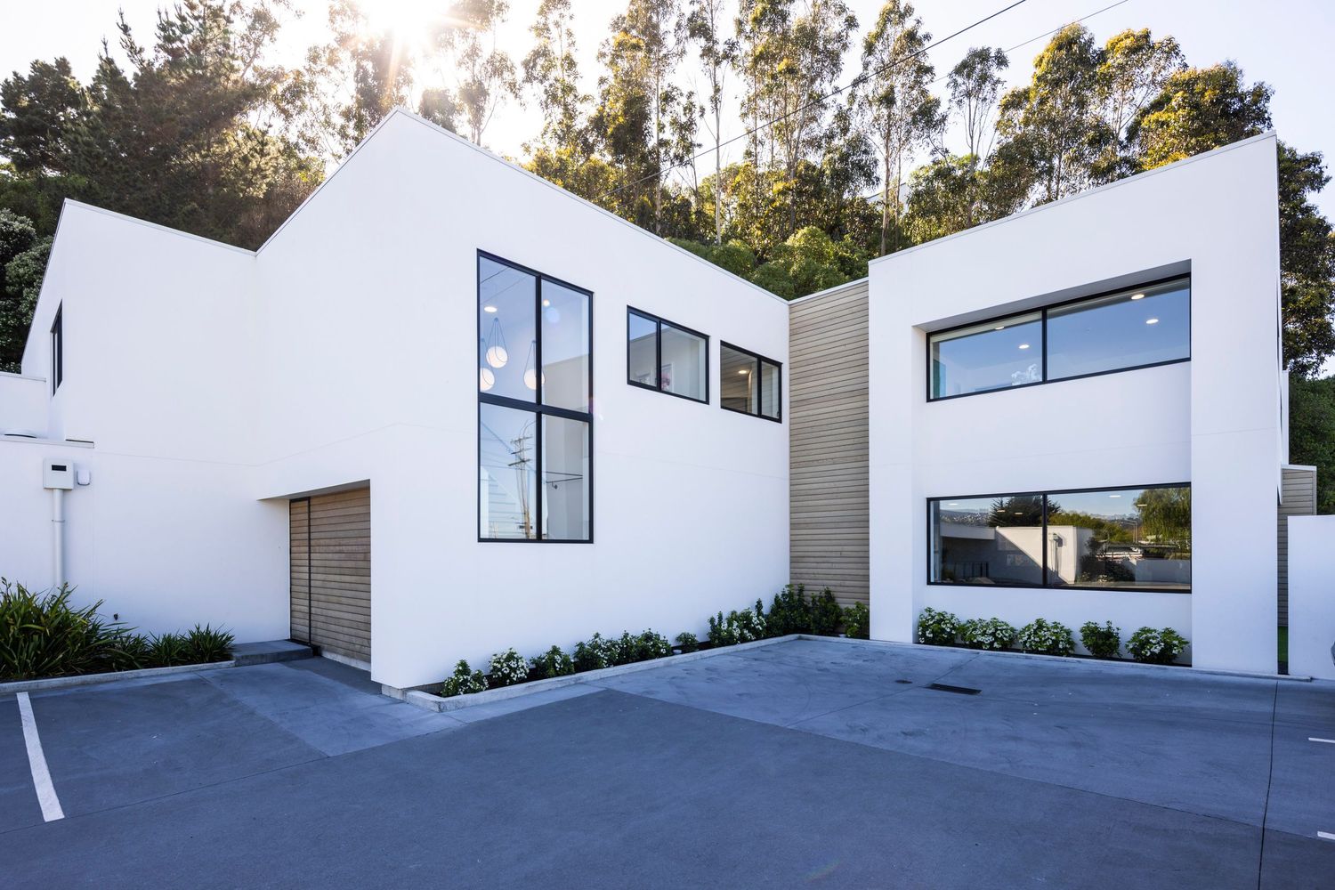 Angular white modern building with geometric design and black-framed windows.