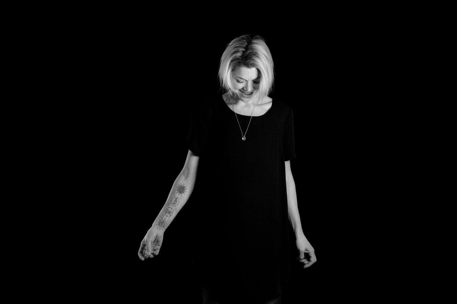 Dramatic black and white portrait against dark background.