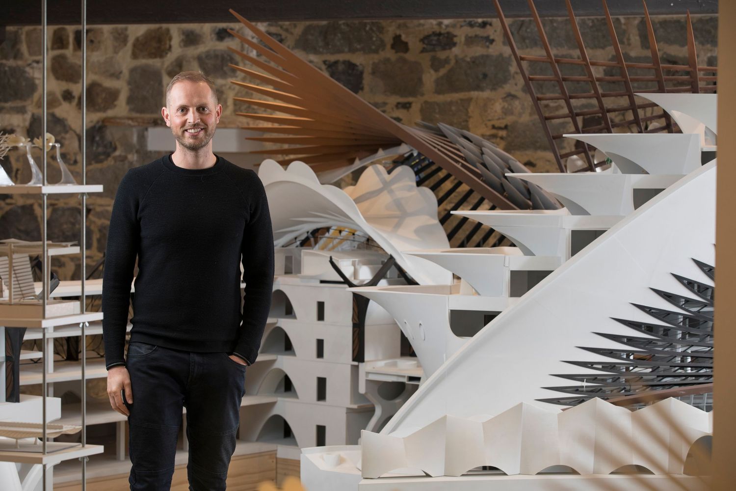 Abstract geometric wall installation featuring white architectural models and sculptural elements.