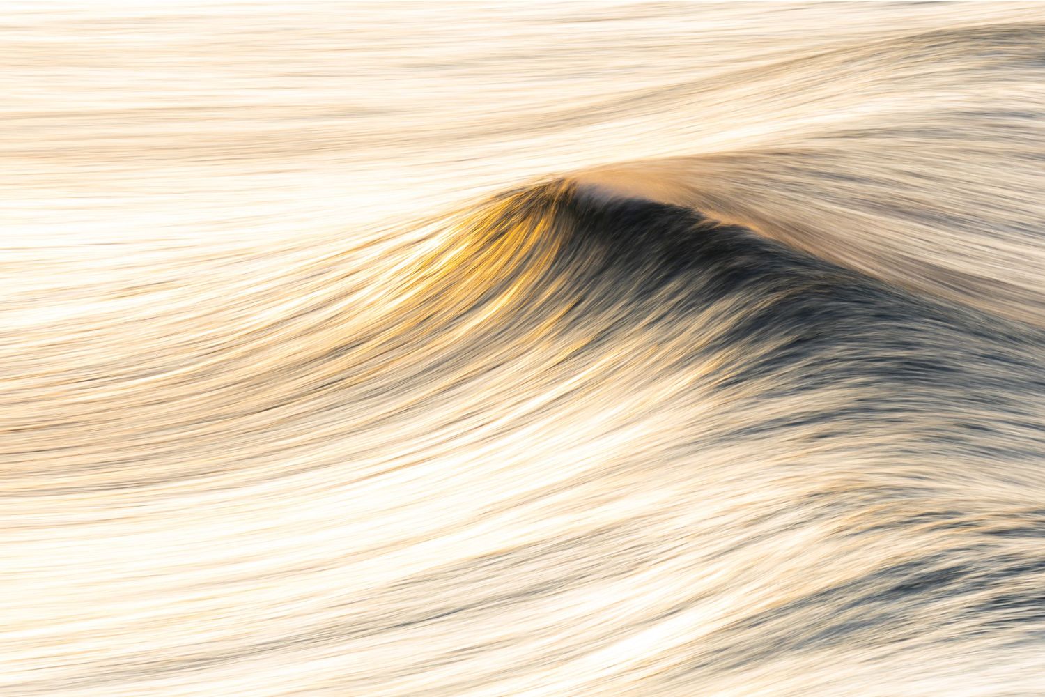 Smooth golden waves create abstract patterns in flowing water during sunset.