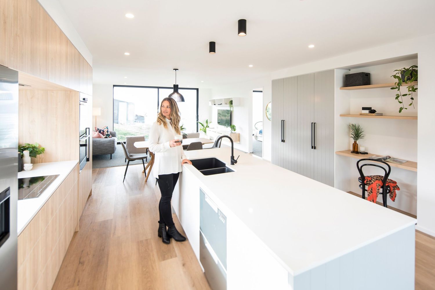 White modern kitchen interior with clean lines and natural light flowing through large windows.