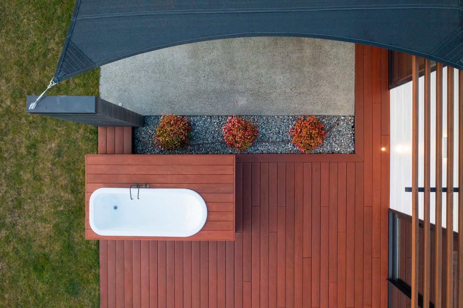 Aerial view of modern home with rust-colored cladding and geometric roofline.