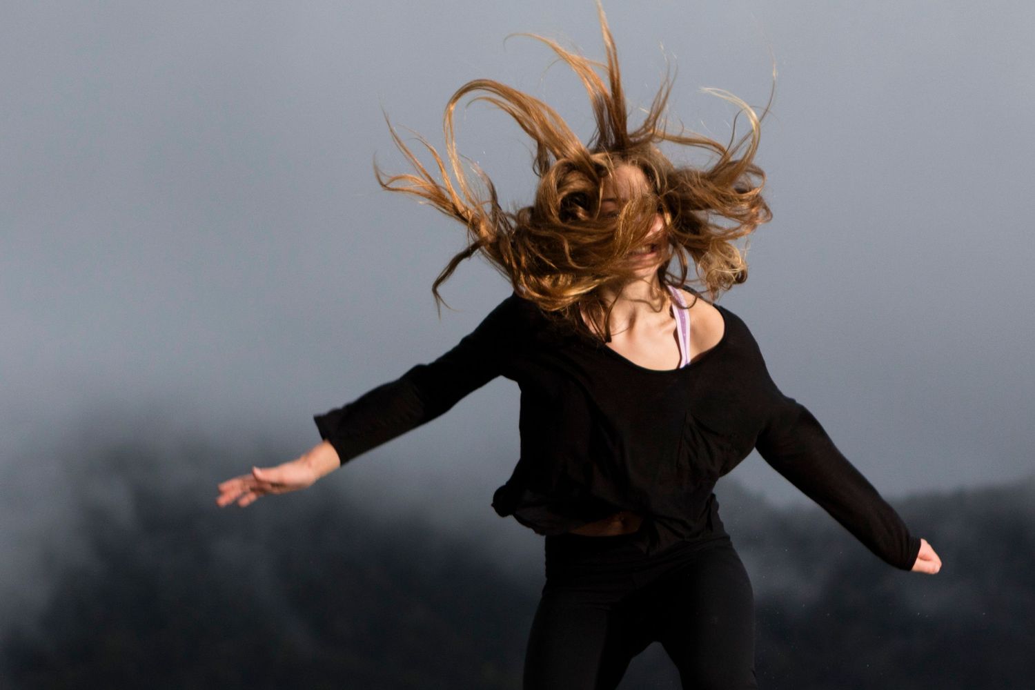 Dynamic dance poses captured in silhouette against a moody gray background.