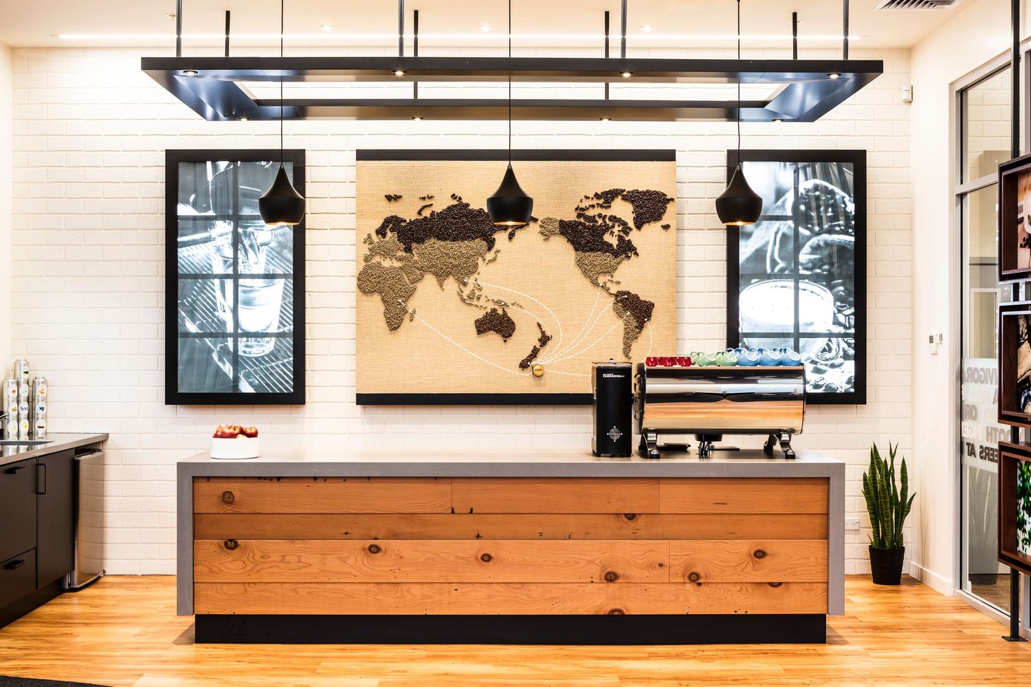 Rustic wooden reception desk with world map artwork and industrial pendant lighting.