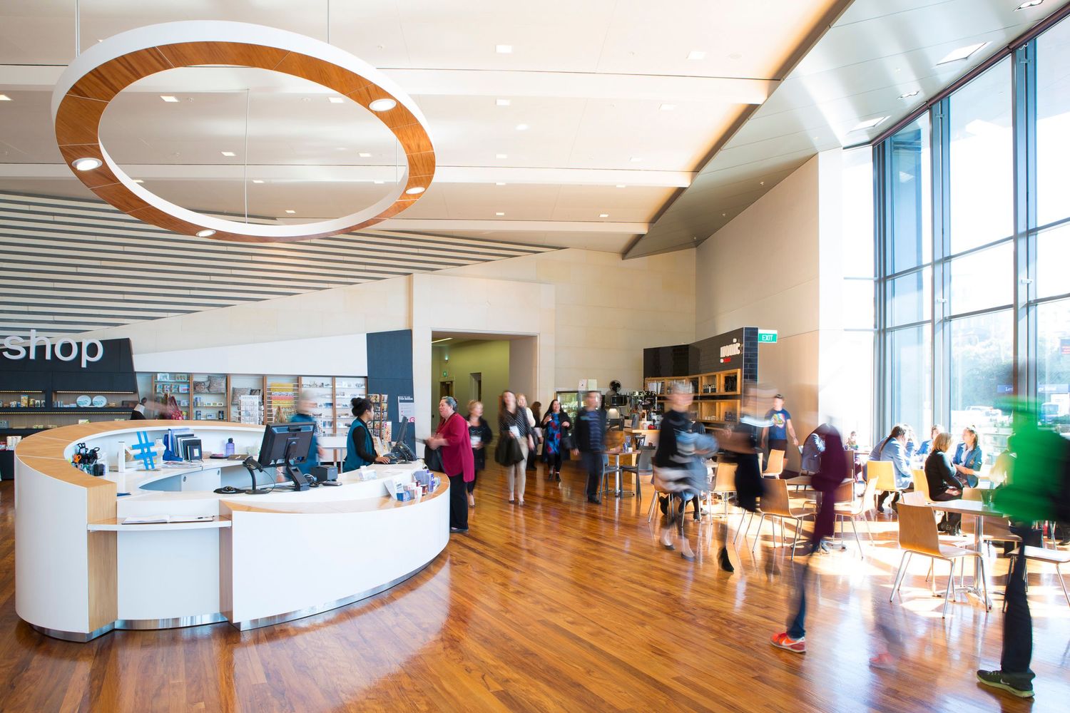 Modern open concept office space with circular lighting fixtures and large windows.