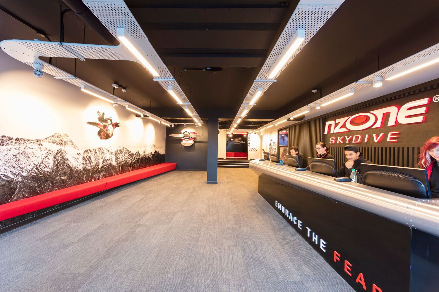 Modern fitness facility interior with red accents and mood lighting.