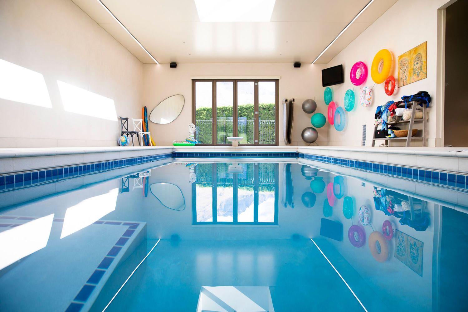 Indoor swimming pool facility with colorful wall decorations and large windows for natural light.