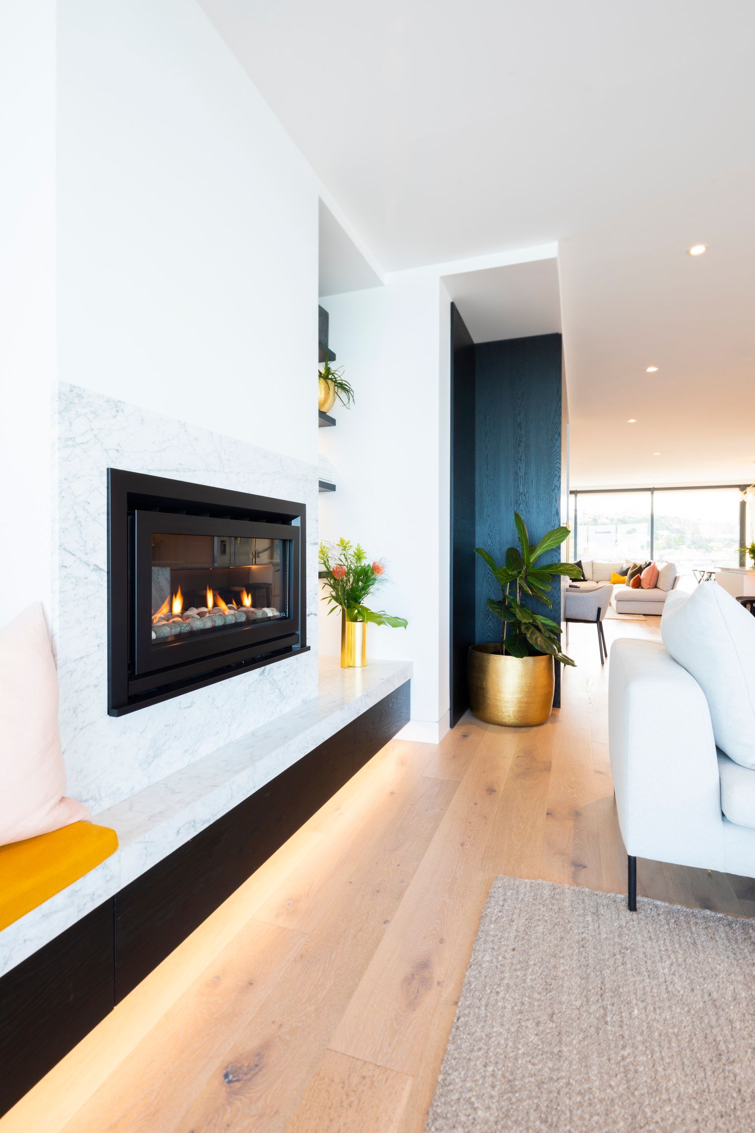 Modern living room with built-in fireplace, hardwood floors and contemporary decor.