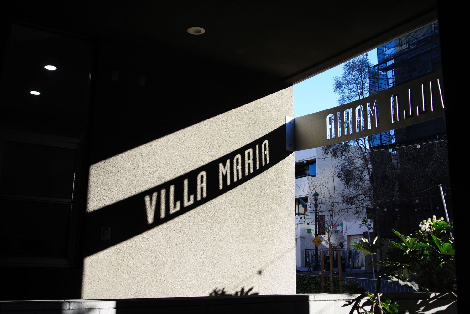 Modern building facade with stark white walls and dramatic shadows in evening light.