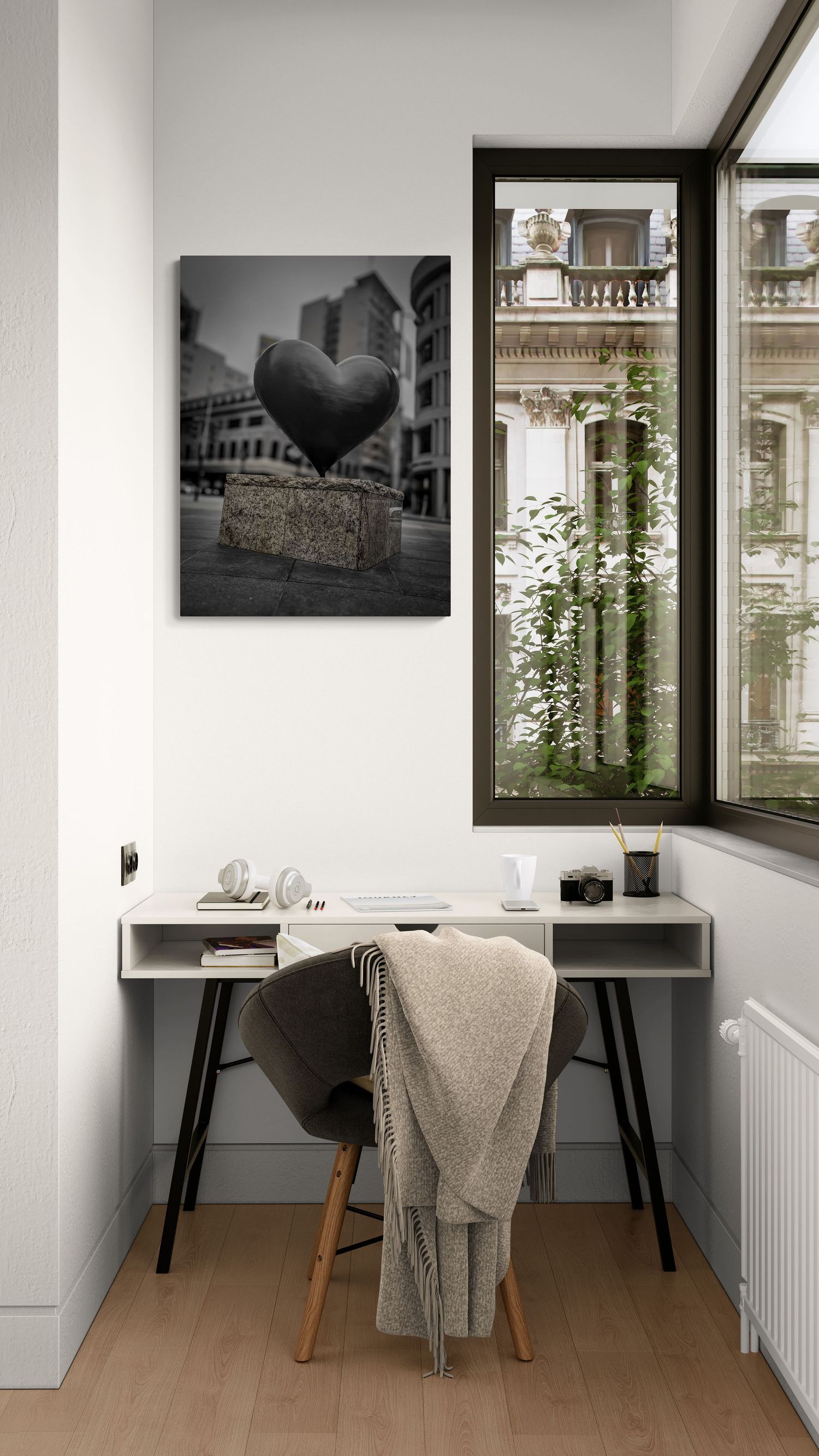 Minimalist home office space with black desks and monochrome wall art near windows.
