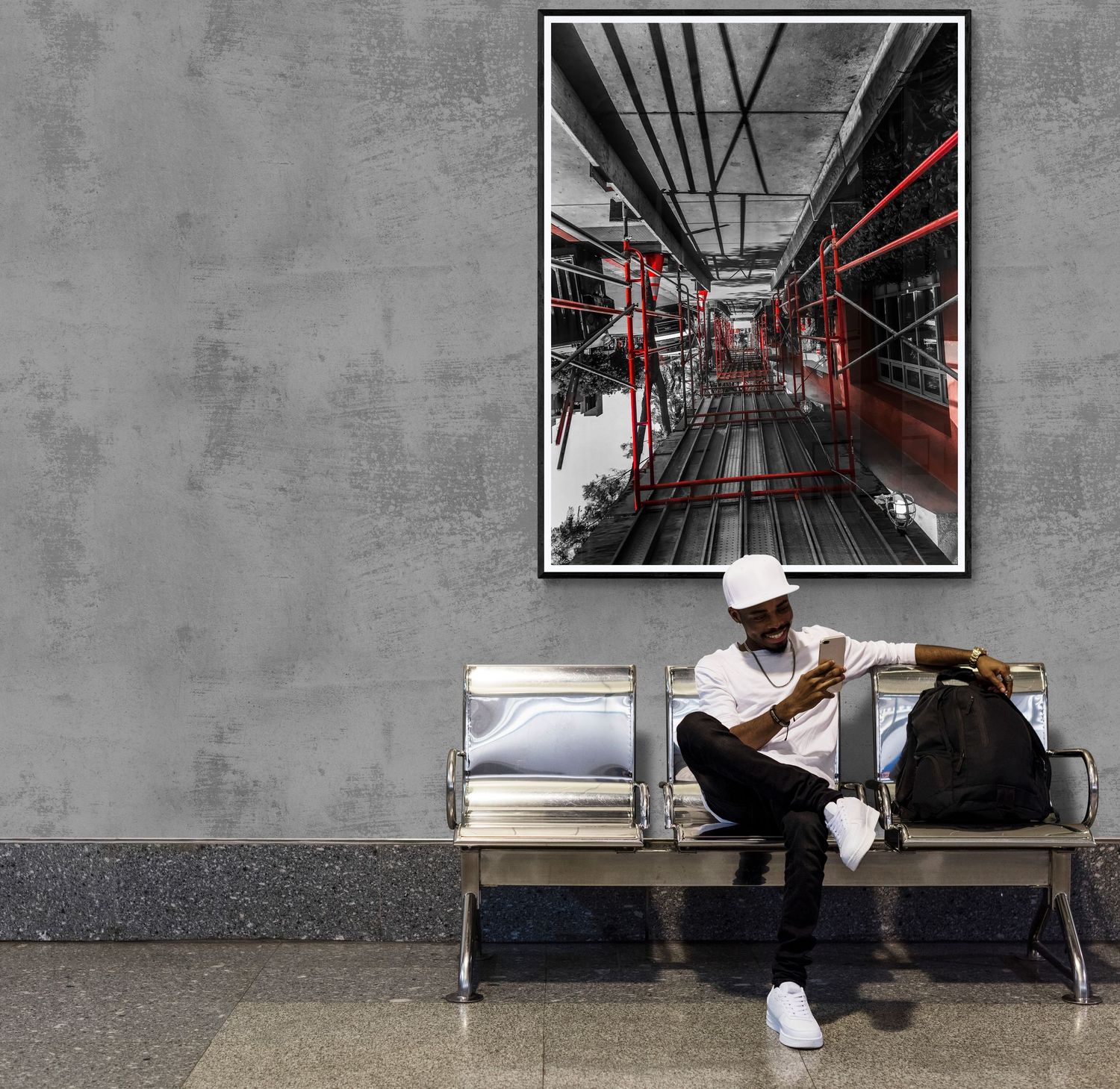 Industrial-style corridor with black and red architectural photographs mounted on concrete walls.