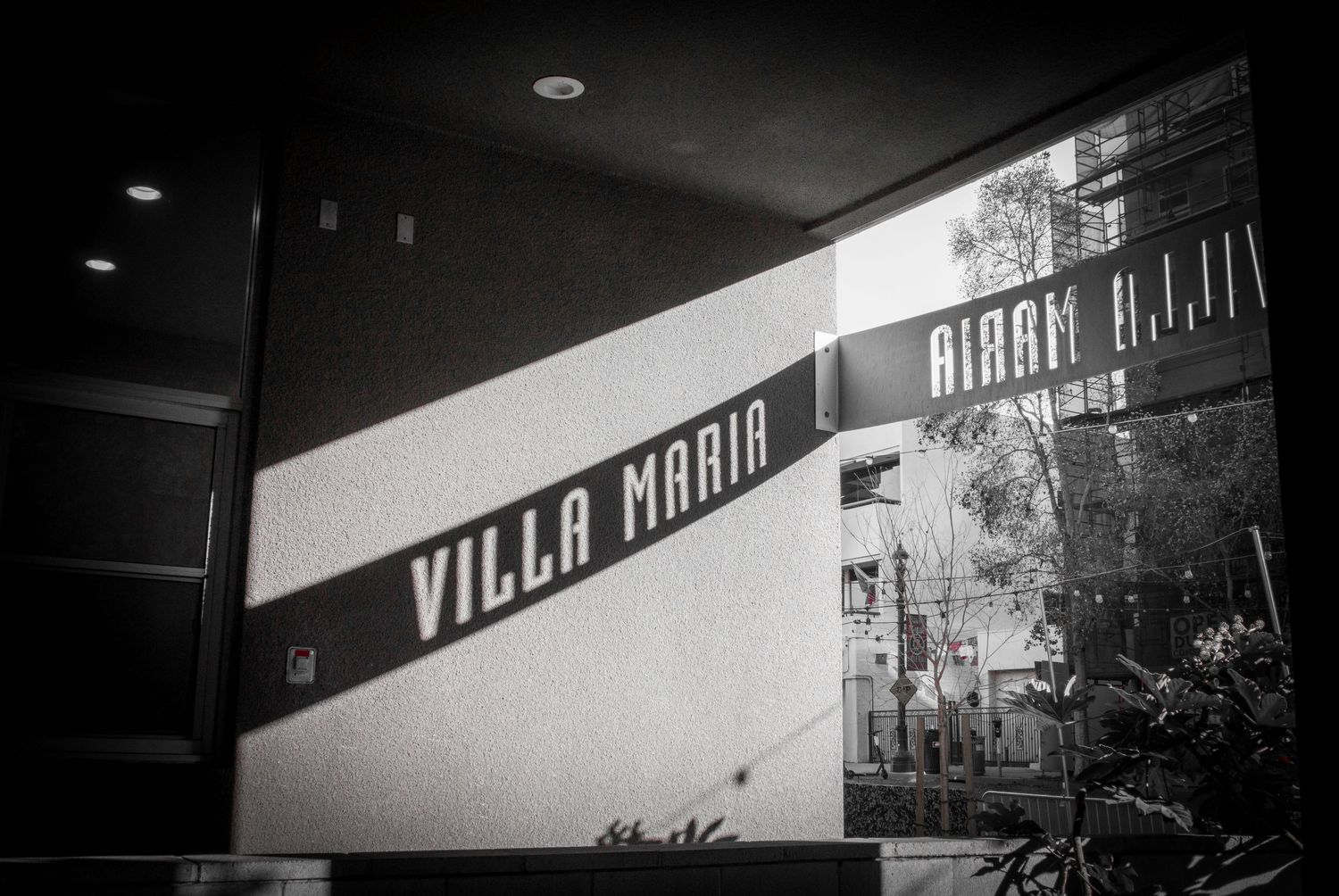 Black and white photograph of a retro Villa Maria sign on a building wall.