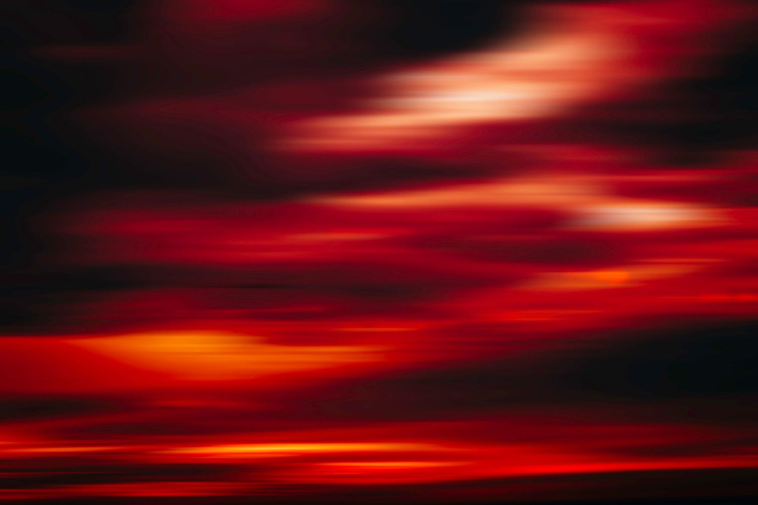 Dramatic red and orange sunset sky with streaking clouds creating an intense atmospheric effect.