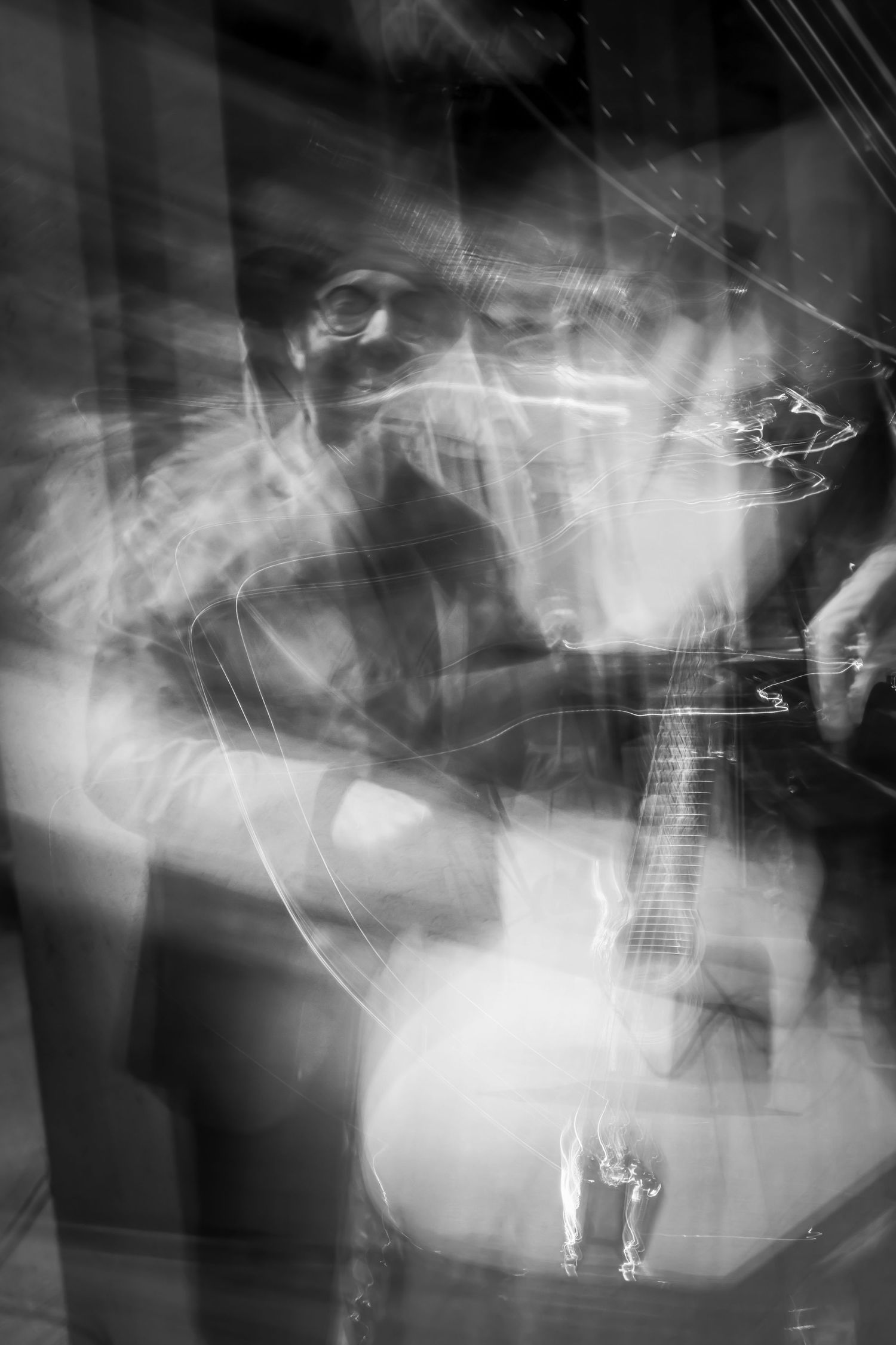 Abstract black and white long exposure photograph showing blurred motion and light trails.