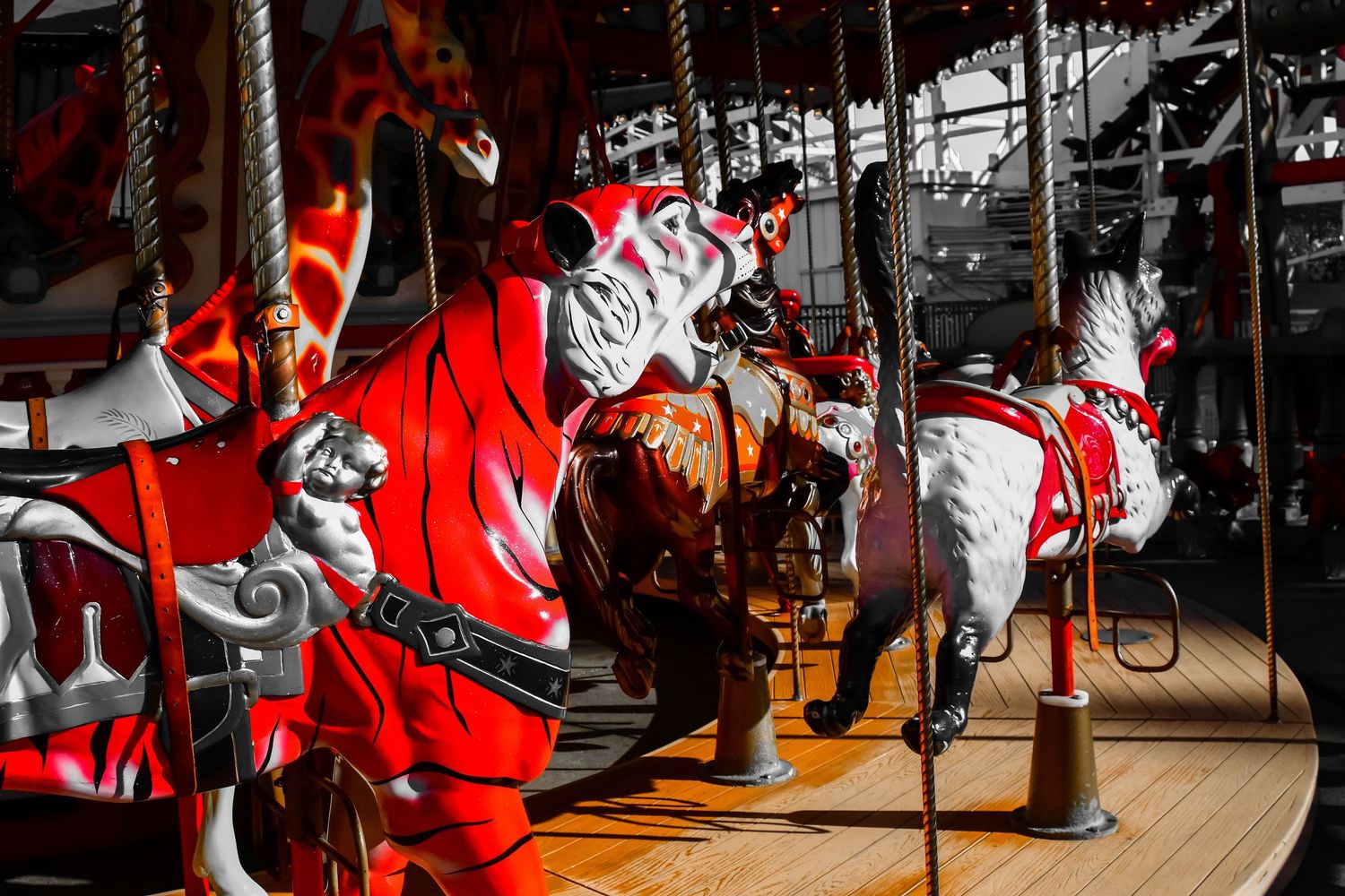 Vintage carousel horses in red and white colors illuminated against dark background.
