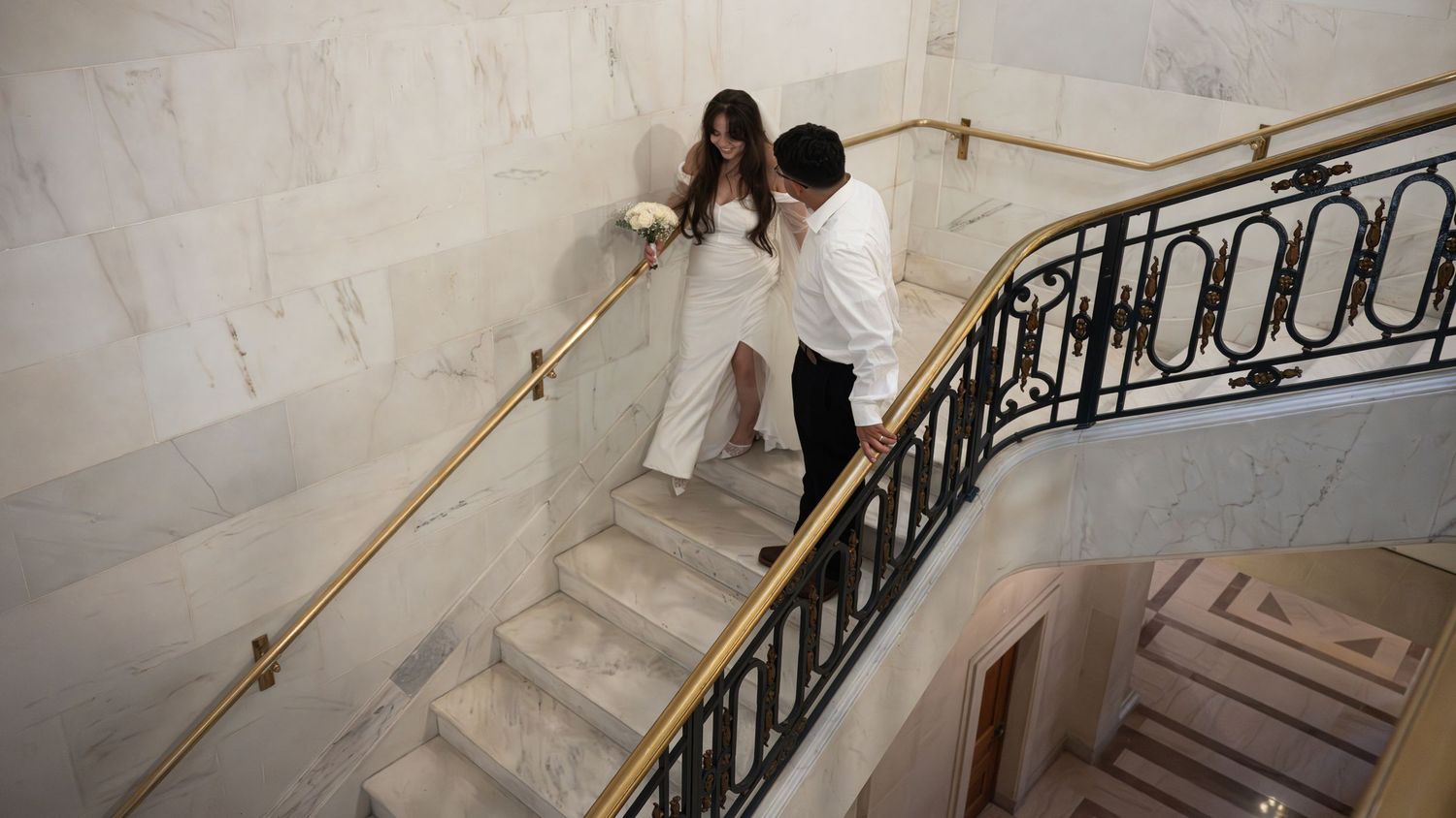 Wedding photo sequence captured on an elegant marble staircase with iron railings.