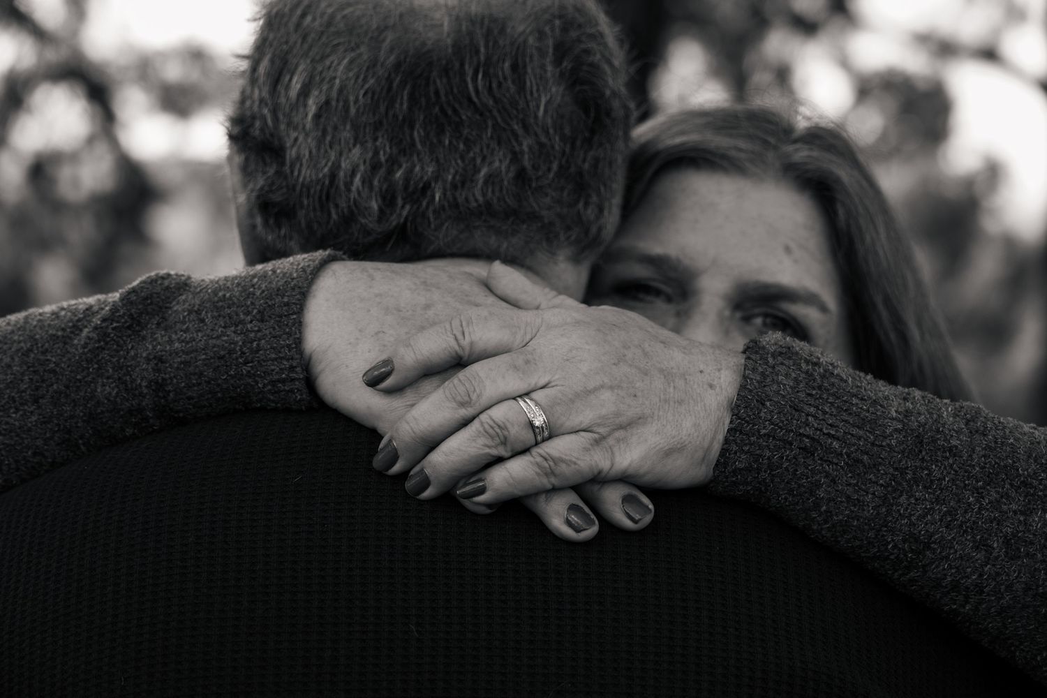 Black and white photo showing hands gently touching and embracing in an intimate moment. Jolie & Rae Photography, couples portrait