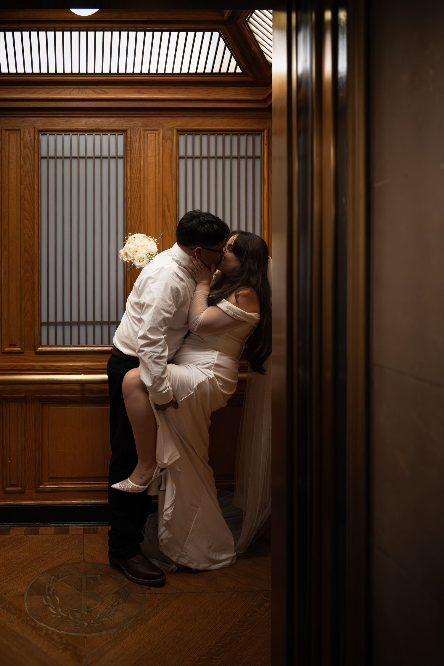 Artistic wedding photos taken in a wood-paneled hallway with dramatic lighting.