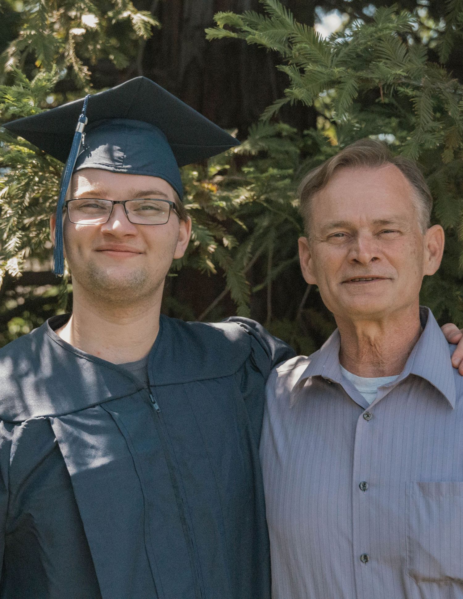 Graduating male student with father smiling outdoors, high school senior portrait near Sacramento California Jolie & Rae Photography