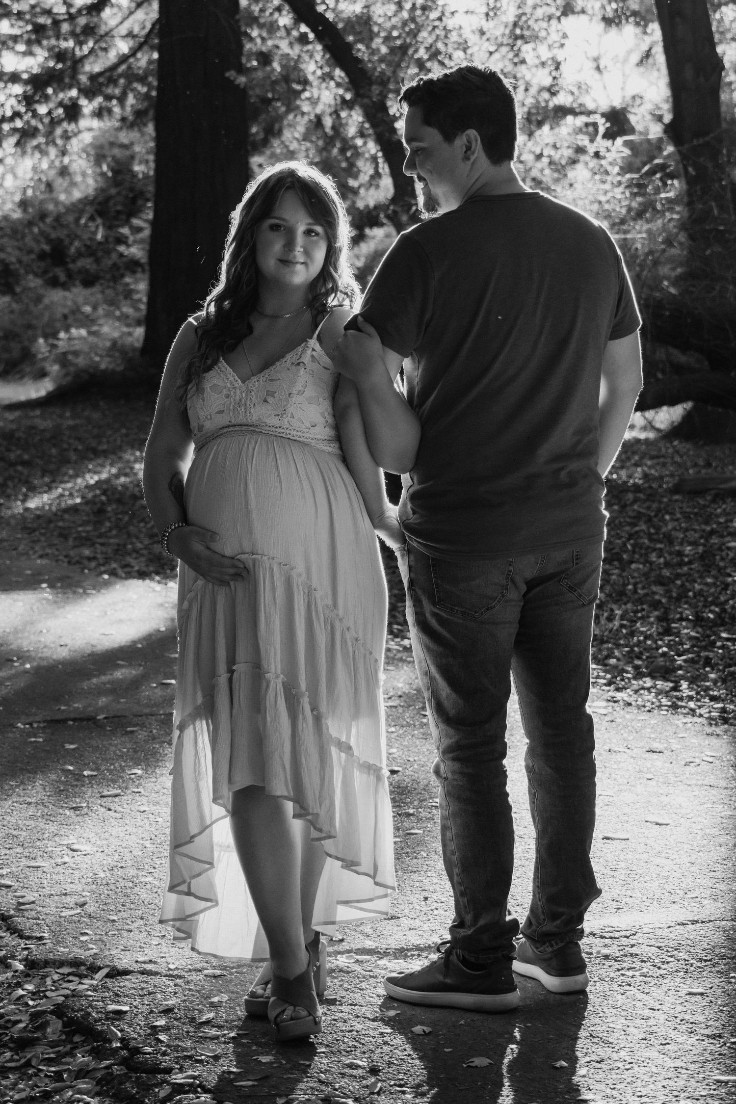 A series of black and white photos showing a couple walking together on a wooded path in romantic silhouettes.