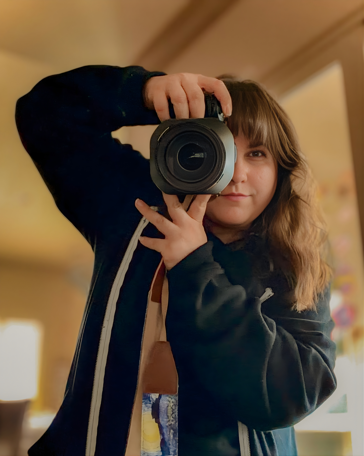 Person in a navy sweater taking a photo with a professional camera.