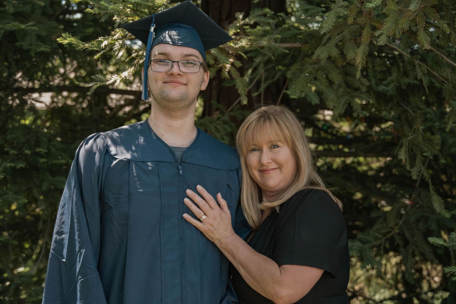 Graduate standing with mother outdoors, cap and gown graduation photos near Rocklin CA, Jolie & Rae Photography