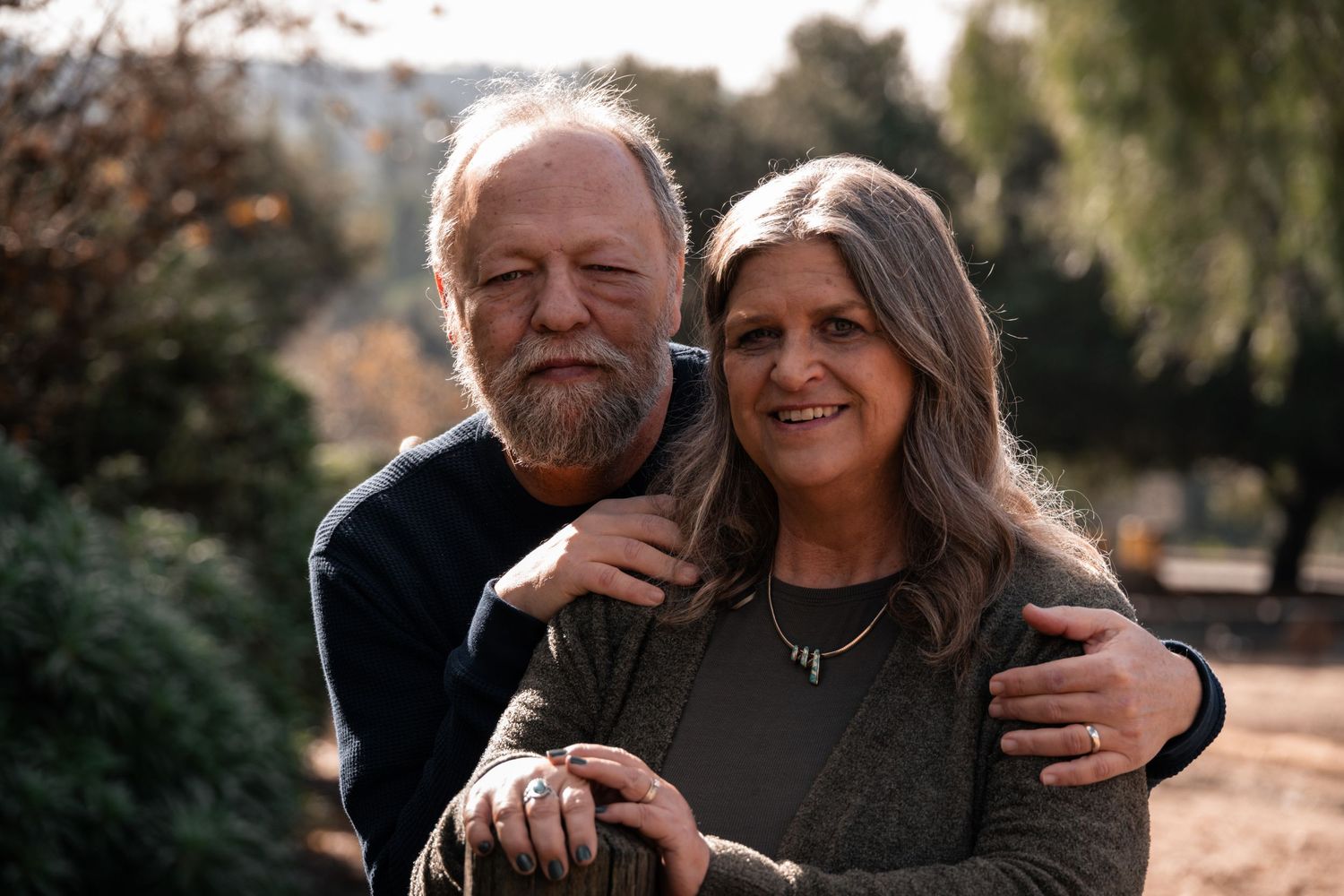 Middle aged couple in outdoor couples photo shoot smiling at camera in playful pose by Jolie & Rae Photography in Los Angeles, traveling
