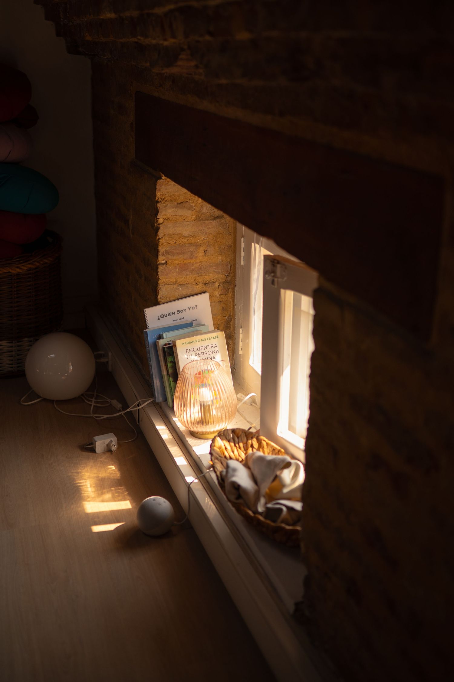 Sunlit window ledge in a rustic brick room creating dramatic shadows.