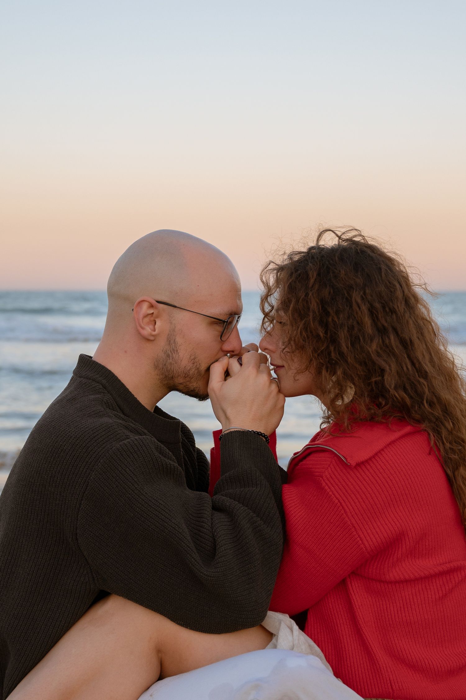Romantic couple sharing intimate moments at sunset by the beach.