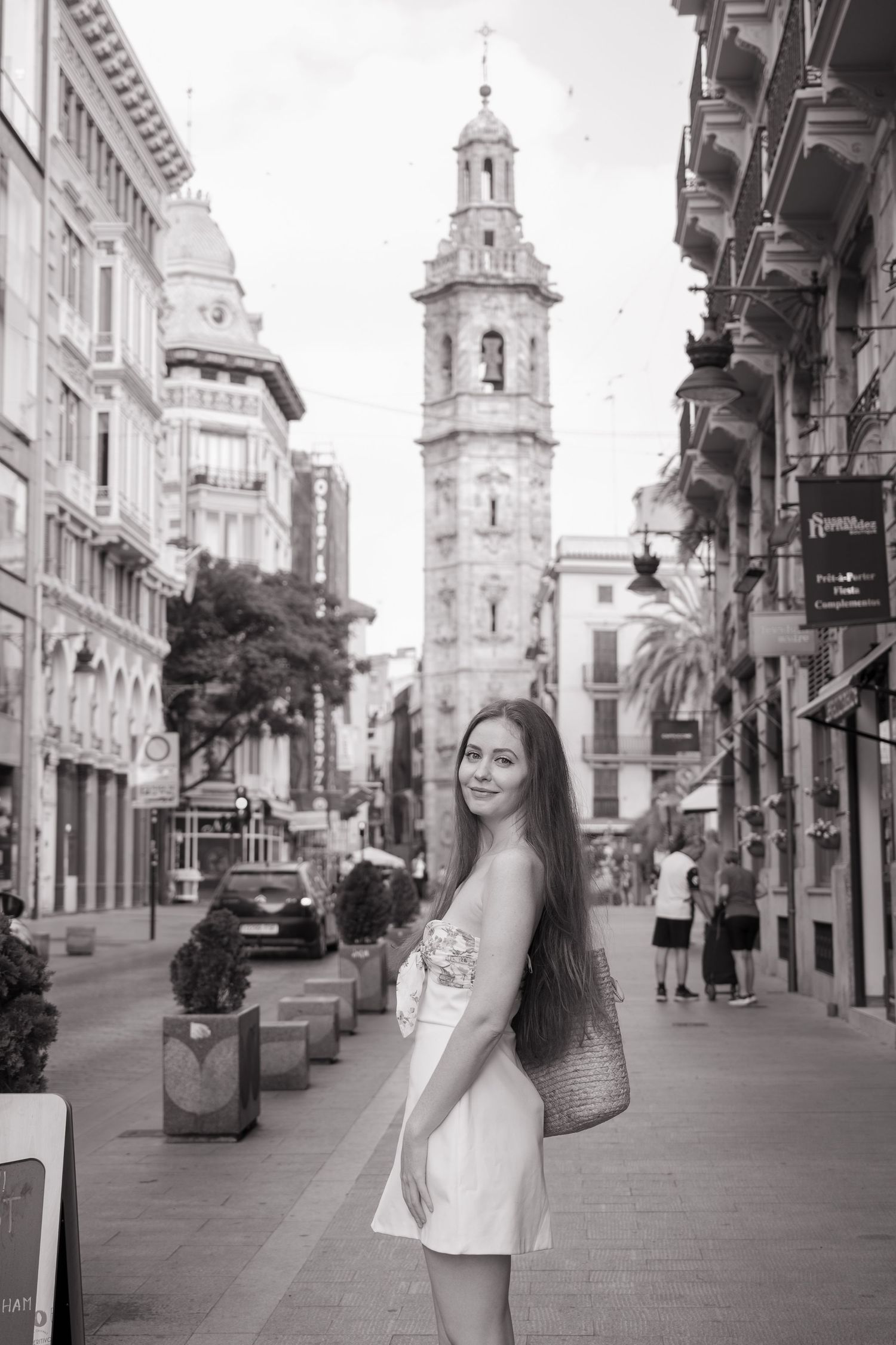 Black and white street scene with historic architecture and bell tower.